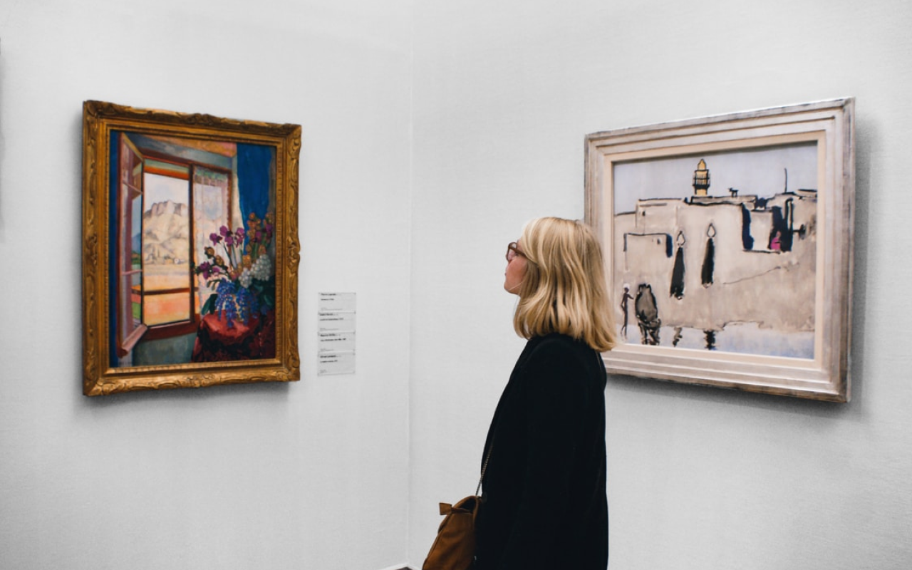 woman looking at artwork on white walls